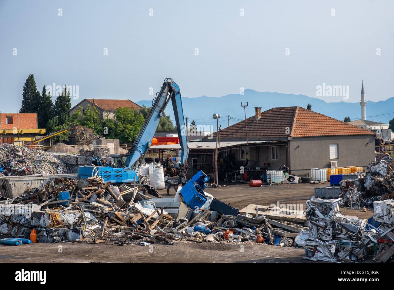 Greifkran arbeitet im Abfallverwertungs- und Sortierzentrum. Recyclingzentrum für Altmetall zum Sortieren von Metall, Aluminium, Messing, Kupfer, Edelstahl von Stockfoto