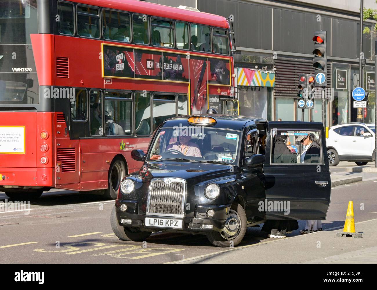 London, England, Großbritannien - 22. August 2023: Ein schwarzes Londoner Taxi hielt an, um Passagiere auf der Oxford Street abzuholen Stockfoto