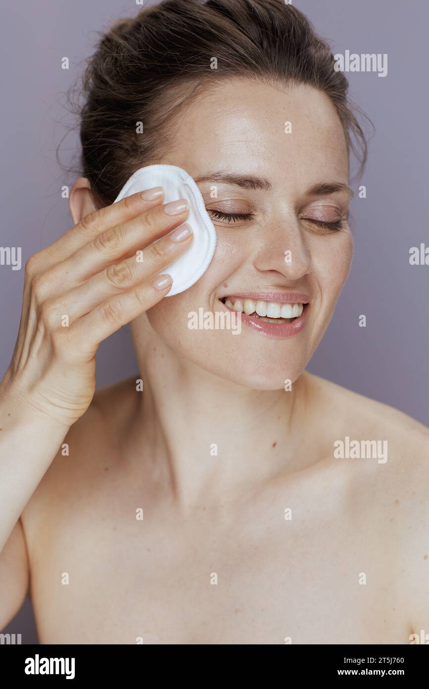 Lächelnde moderne Frau mit Wattepad isoliert auf blauem Hintergrund. Stockfoto