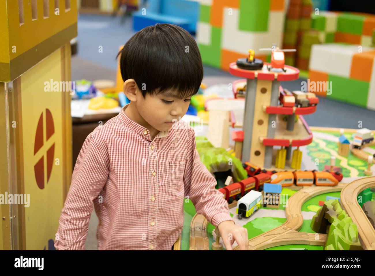 Kleiner asiatischer Junge, der mit Spielzeugauto im Kinderspielplatz spielt Stockfoto