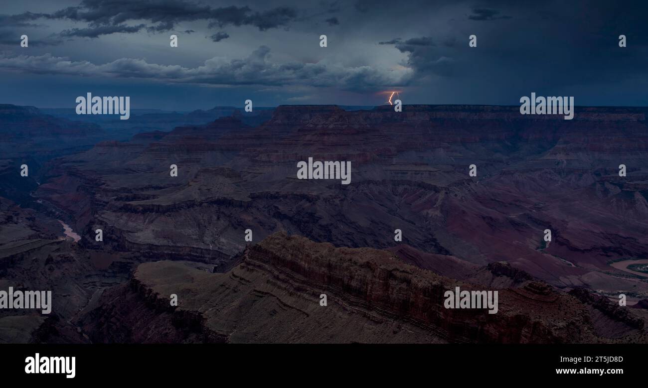 Entfernte und traumhafte Blitze treffen außerhalb des Nordrandes, die während der blauen Stunde der Dämmerung vom Grand Canyon aus gesehen werden. Stockfoto