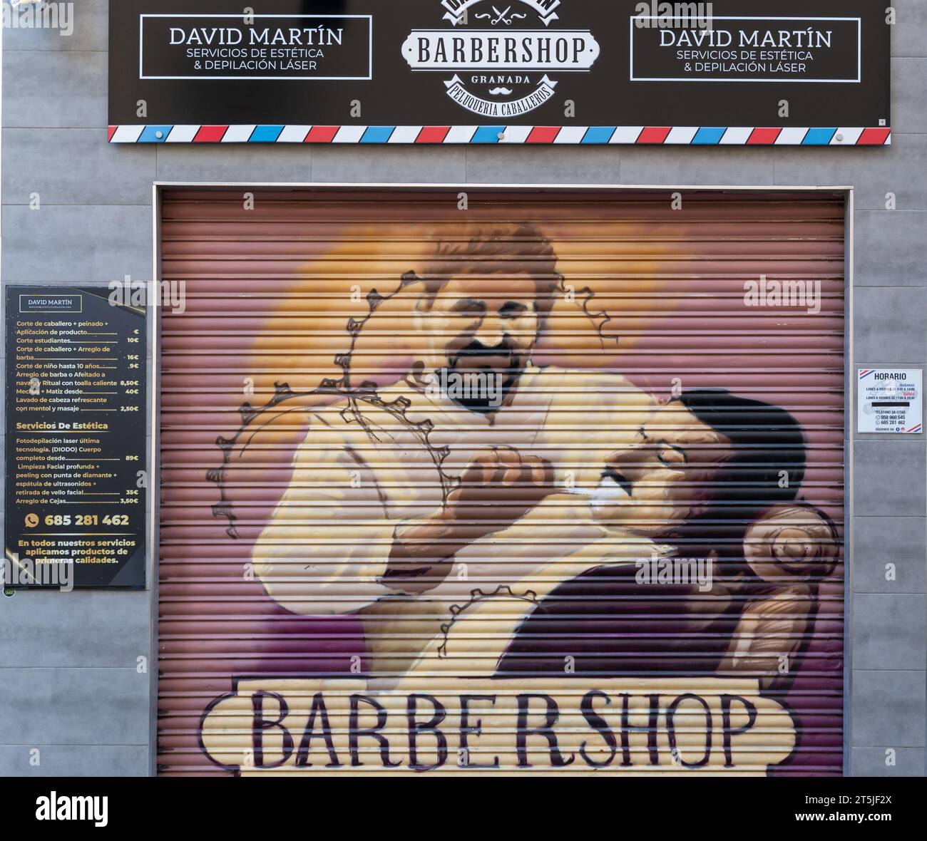 Granada, Spanien; Oktober-08, 2023: Schönes Gemälde eines Friseurs, der einen Mann auf den Jalousien eines Friseurs rasiert Stockfoto