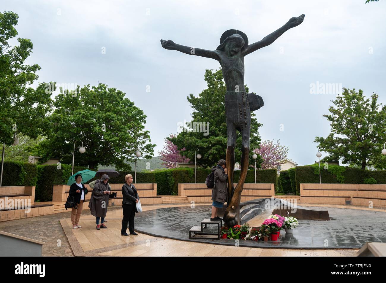 Menschen, die die Statue des Christus in Medjugorje verehren. Die Statue weint auf wundersame Weise Tropfen Flüssigkeit aus Jesu rechtem Knie. Stockfoto