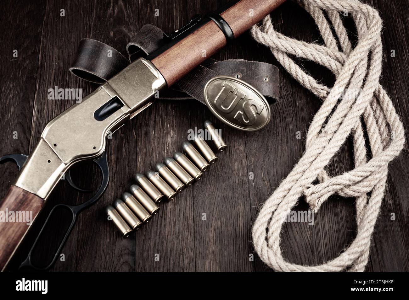 Ein Repetiergewehr mit Druckpatronen und US-amerikanischer Bronzestraße auf Holztisch Stockfoto