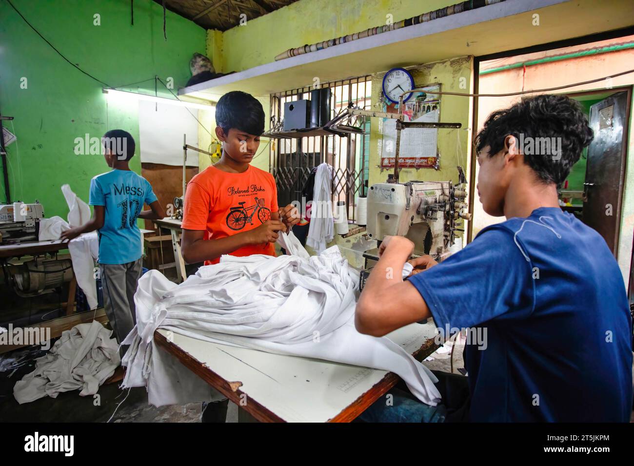 Kinder, die in einer lokalen Fertigwarenfabrik (Ready Made Garment, RMG) arbeiten, wo sie im Vergleich zu ihren erwachsenen Kollegen sehr niedrig bezahlt werden. Die Kinderarbeit ist in den Bereichen Fertigwaren (RMG) eingeschränkt. Es gibt jedoch immer noch Kinder, die in vielen lokalen Bekleidungsfabriken arbeiten, die hauptsächlich in städtischen Gebieten betrieben werden und die Hauptstadt Dhaka, Bangladesch, verlassen. Stockfoto