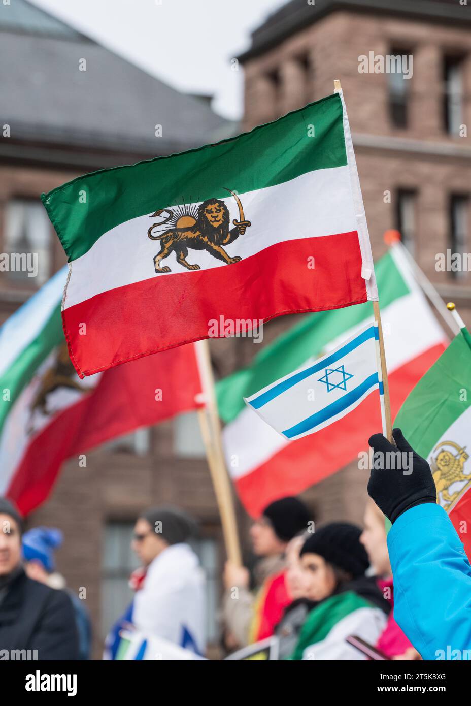 Ein iranischer Löwe und eine Sonnenfahne und eine israelische Flagge werden stolz auf eine Veranstaltung zum Großen Tag des Cyrus AM 29. Oktober 2023 in Toronto geflogen. Stockfoto