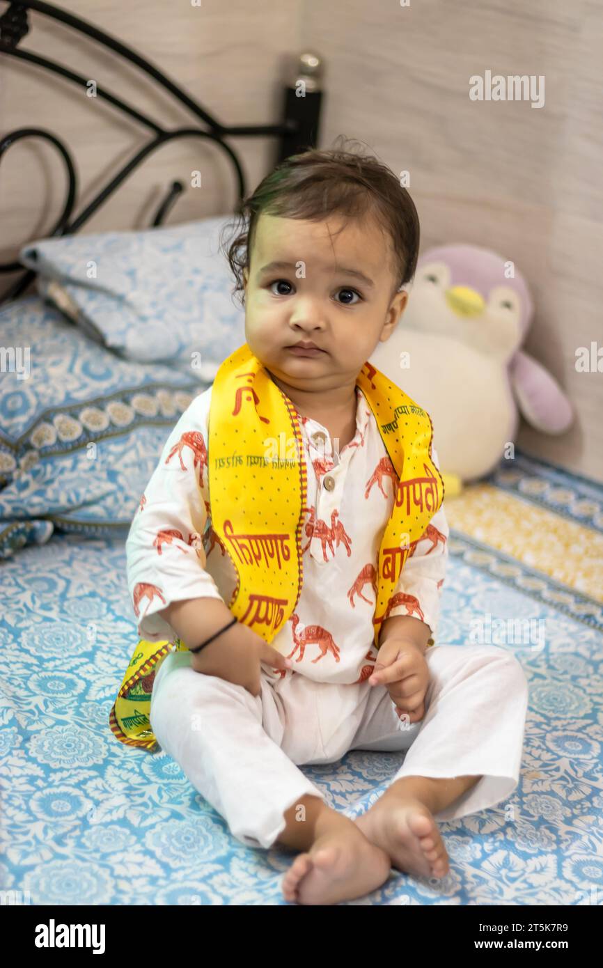 Niedliches Kleinkind Baby Junge, der zu Hause im Bett sitzt Stockfoto