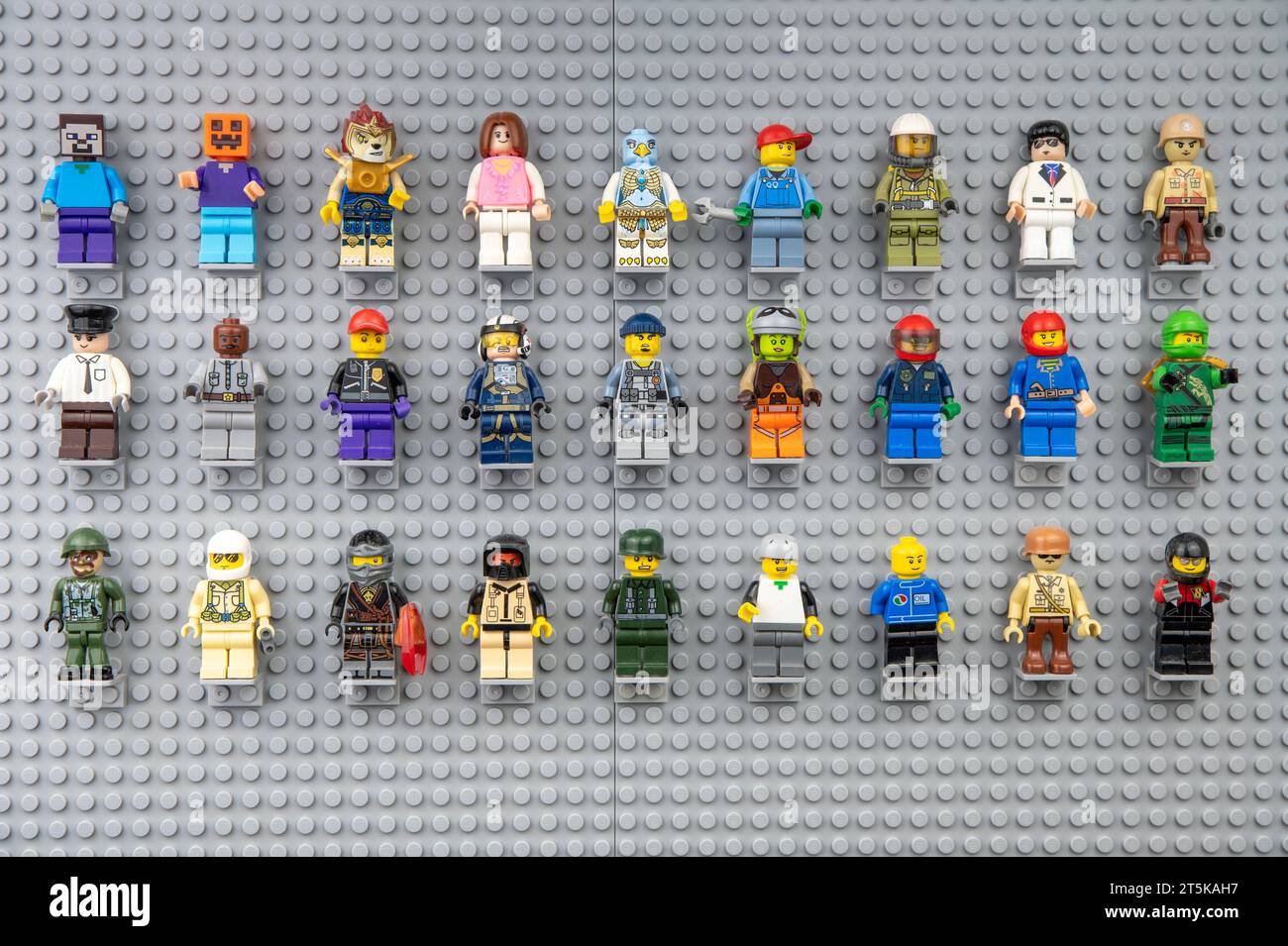 Nova Bana, Slowakei - 5. November 2023 : Lego-Minifiguren an der Wand. LEGO® Minifiguren auf Lego Grundplatten in Reihe. Stockfoto
