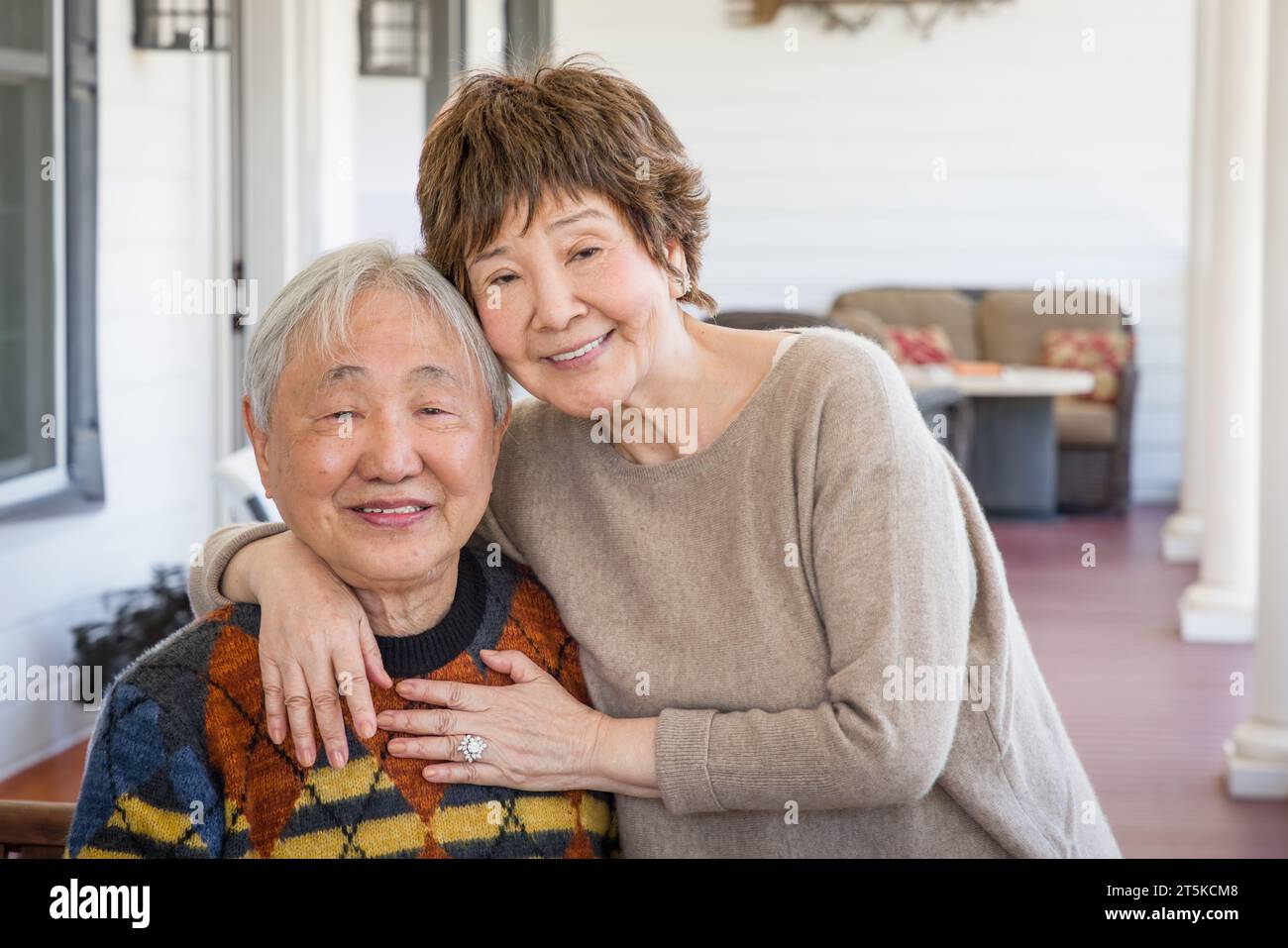Glückliches chinesisches Ehepaar posiert für ihr Porträt auf der Veranda. Stockfoto