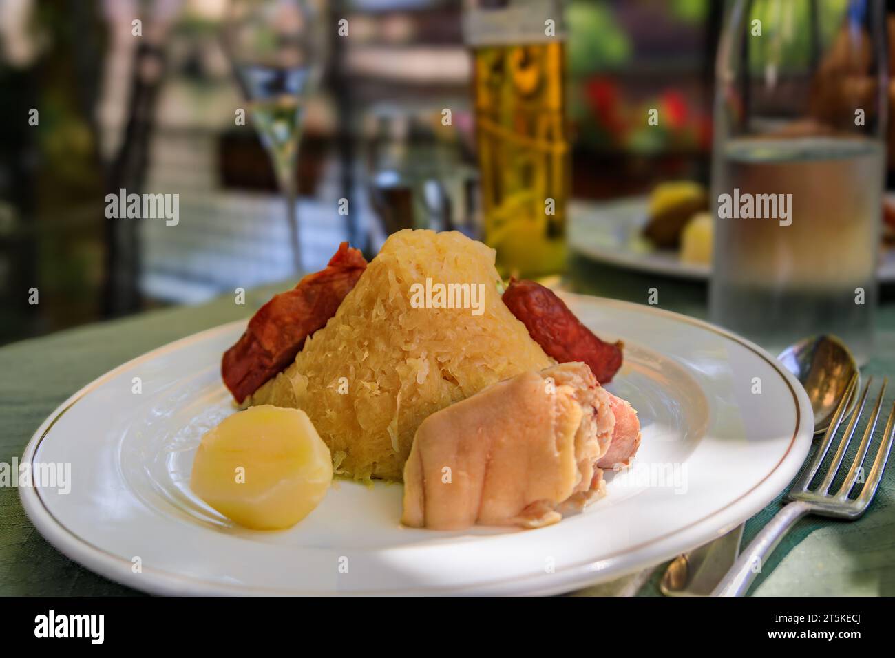 Traditionelle elsässische Choucroute Garnie, Sauerkraut mit Würstchen, Schweinshaxe, anderes Fleisch und Kartoffeln in einem winstub Restaurant in Straßburg, Frankreich Stockfoto