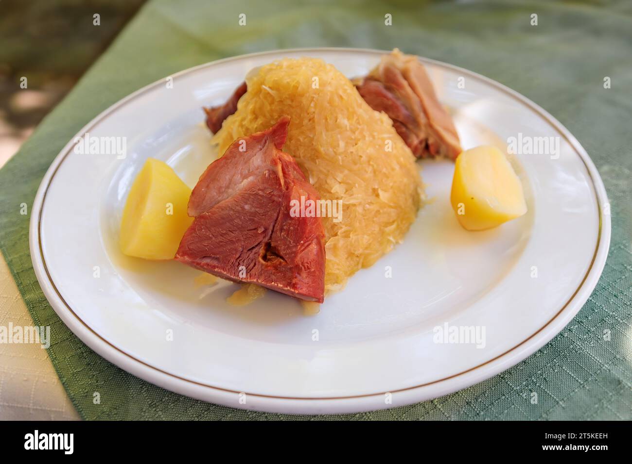 Traditionelle elsässische Choucroute Garnie, Sauerkraut mit Würstchen, Schweinshaxe, anderes Fleisch und Kartoffeln in einem winstub Restaurant in Straßburg, Frankreich Stockfoto