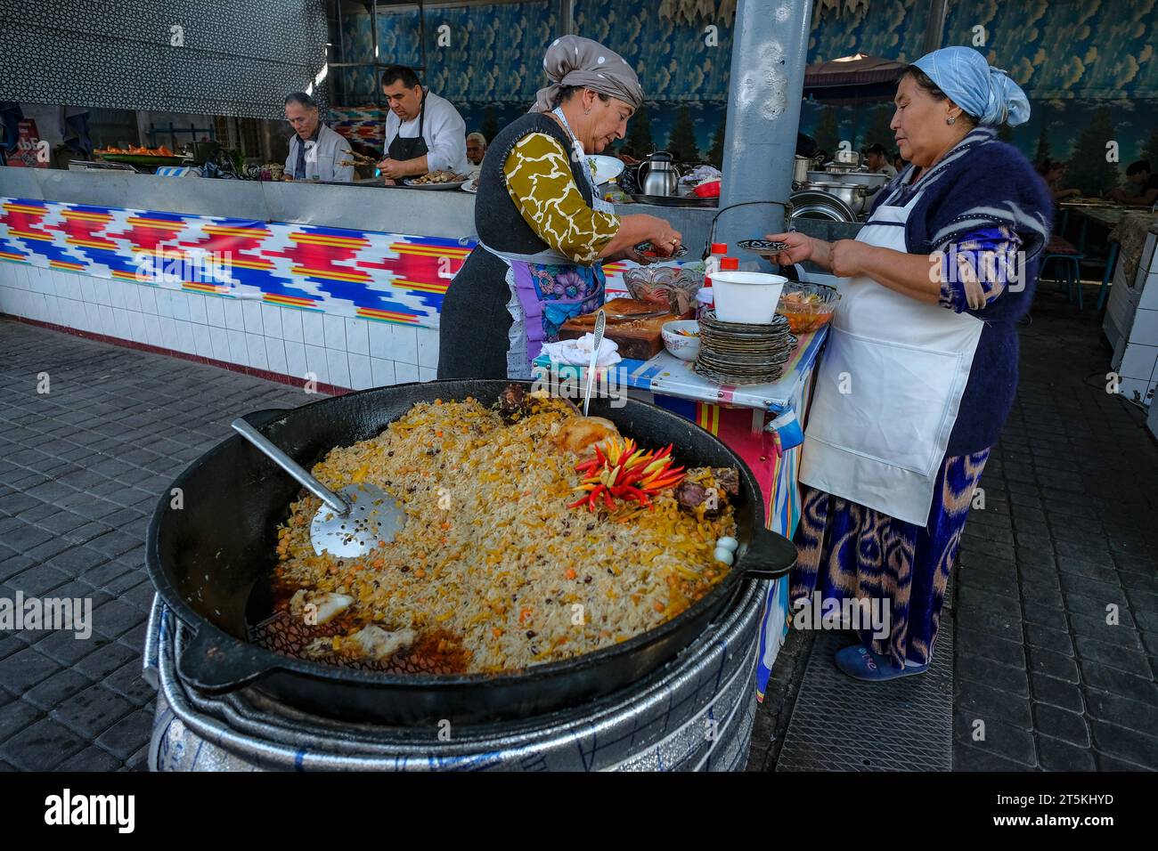Taschkent, Usbekistan - 29. Oktober 2023: Zwei Frauen kochen Reis auf dem Chorsu-Basar in Taschkent, Usbekistan. Stockfoto