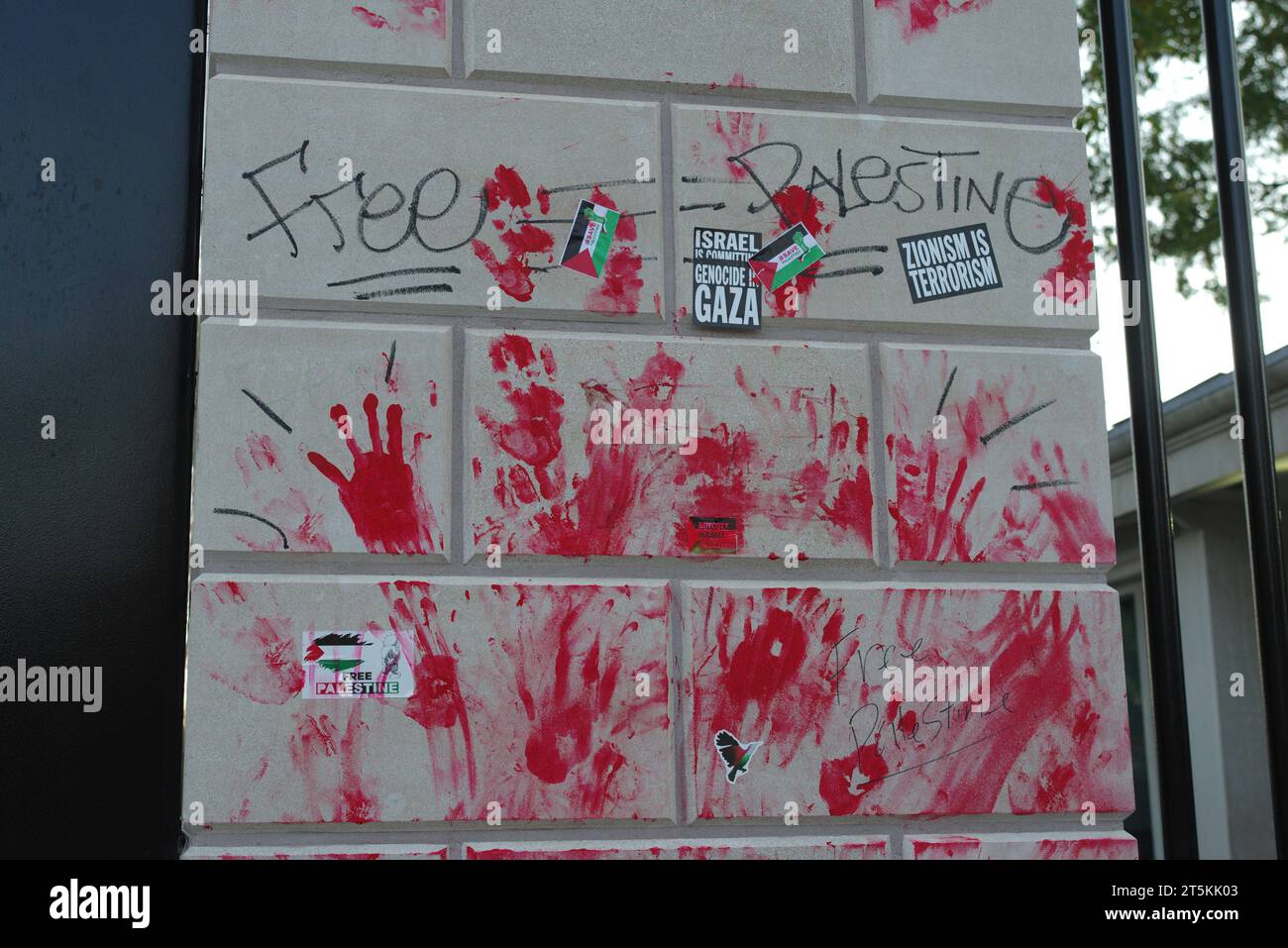 Rote Handabdrücke, Protestaufkleber und Graffiti verbleiben am Tag nach den propalästinensischen Protesten in Washington, DC, an einer Wand entlang eines Tors des Weißen Hauses. Stockfoto