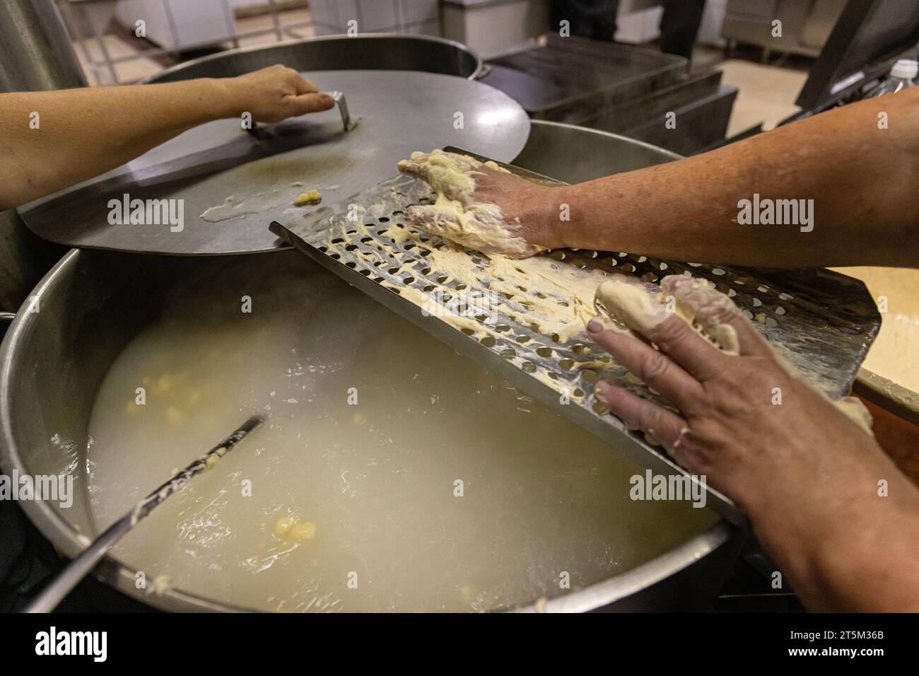 Zubereitung von Eiern in der Restaurantküche. Geriebene Eiertropfennudeln Stockfoto