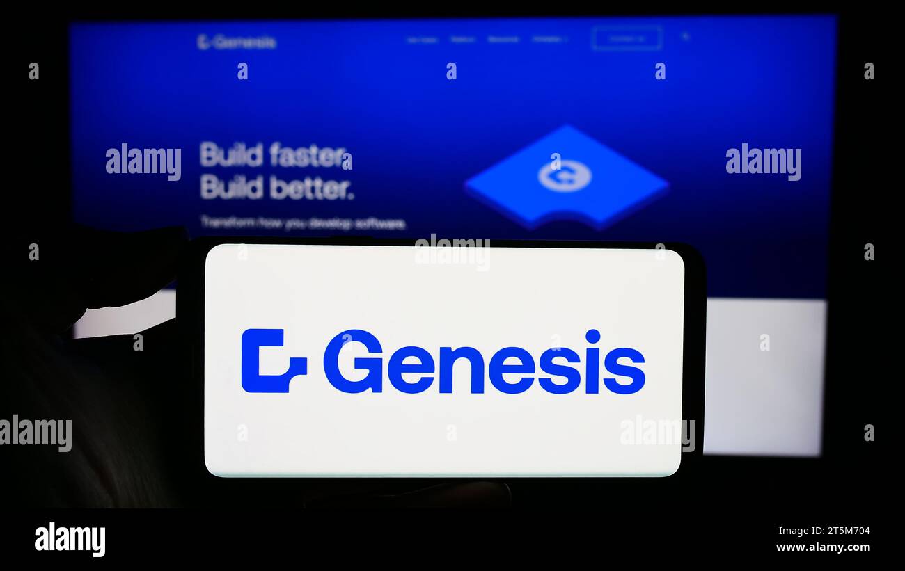 Person mit Smartphone und Logo des britischen Fintech-Unternehmens Genesis Global Technology Limited vor der Website. Schwerpunkt auf dem Display des Telefons. Stockfoto
