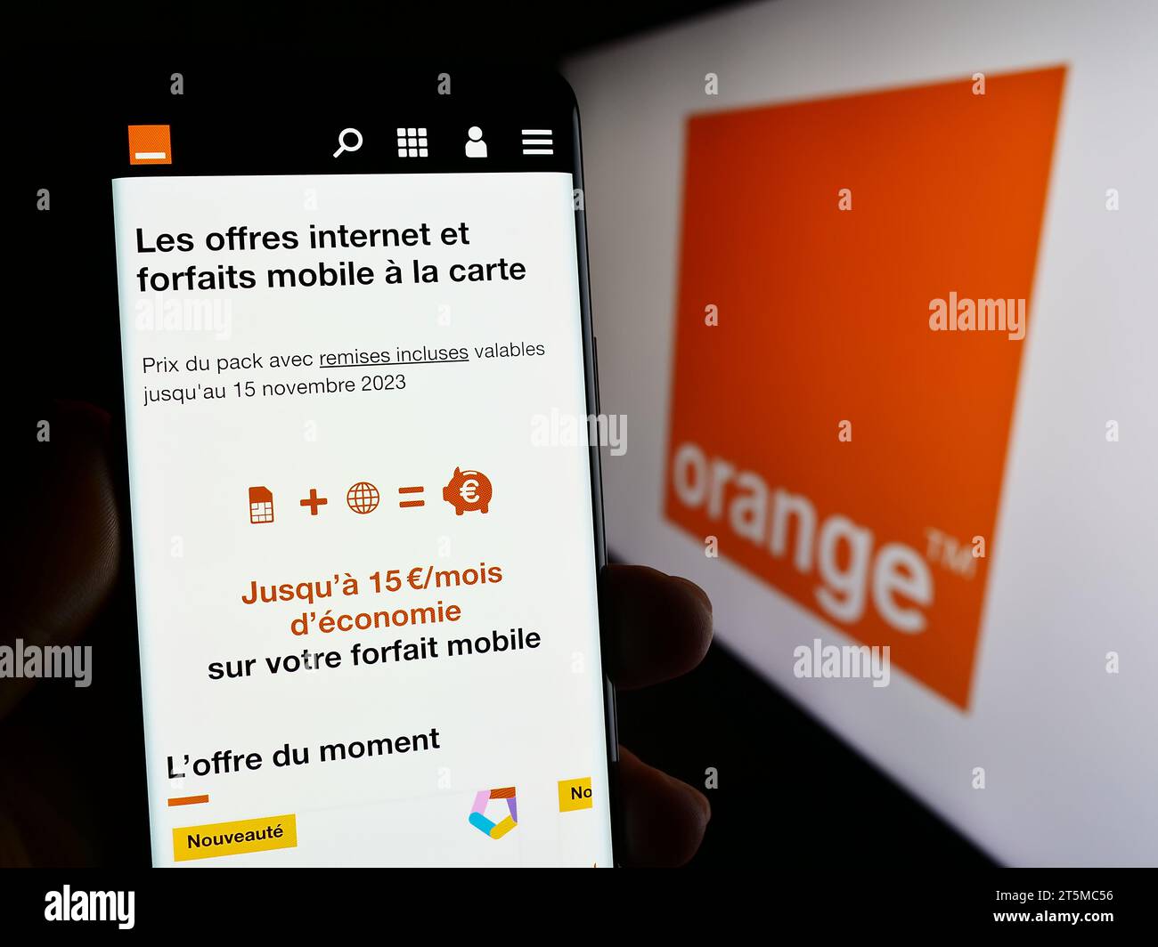 Person mit Mobiltelefon und Webseite des französischen Telekommunikationsunternehmens Orange S.A. vor dem Logo. Konzentrieren Sie sich auf die Mitte des Telefondisplays. Stockfoto