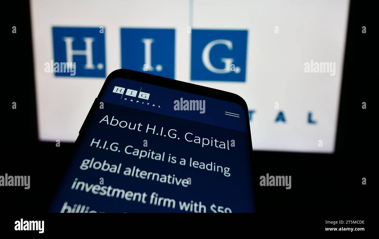 Mobiltelefon mit Webseite der US-Investmentgesellschaft H.I.G. Capital LLC vor dem Firmenlogo. Fokussieren Sie sich oben links auf der Telefonanzeige. Stockfoto