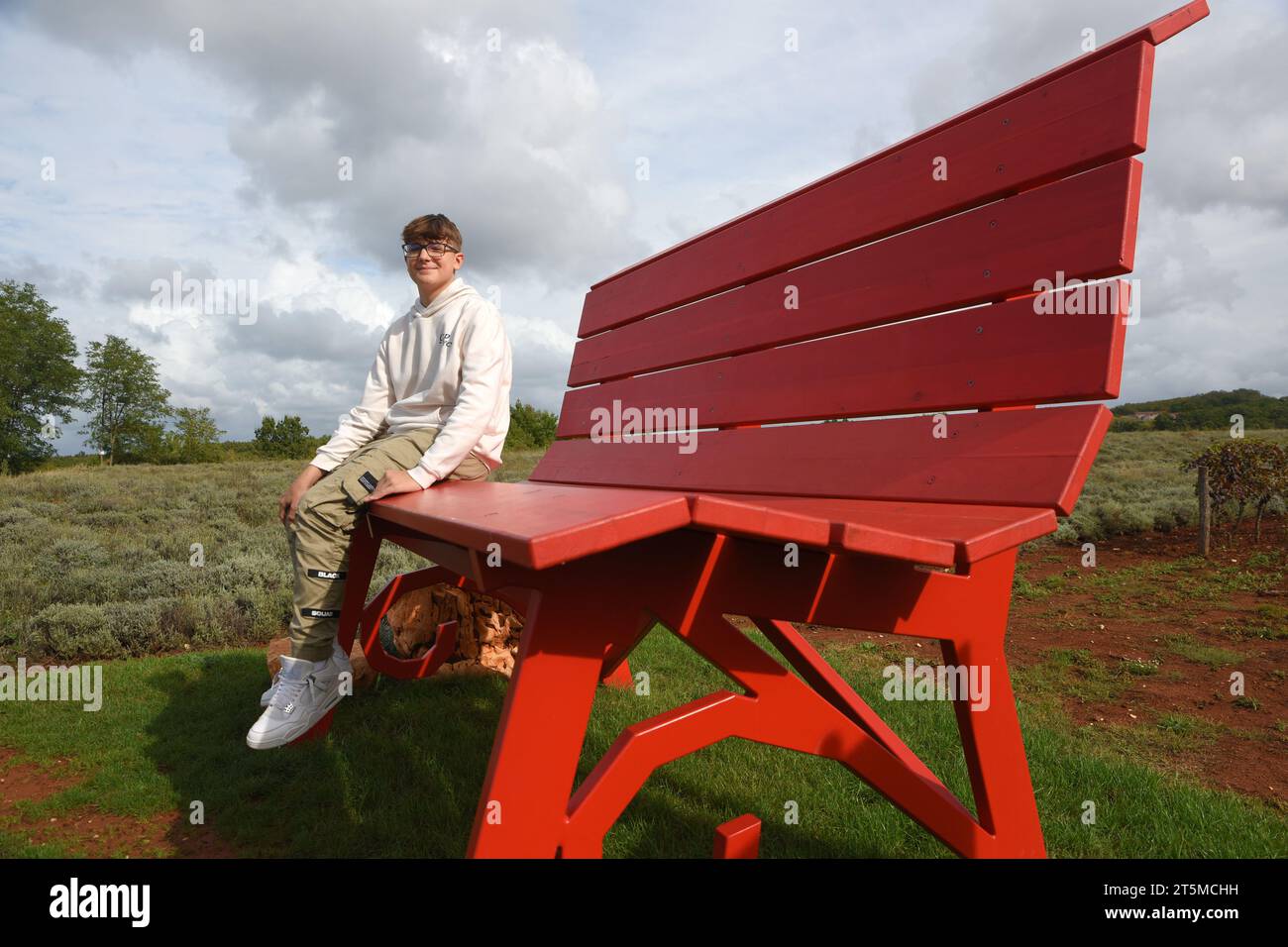 Deklevi, Hrvatska. Oktober 2023. Größte Bank in Kroatien im Rahmen des „Big Bench Community Project“ in Deklevi, Kroatien am 21. Oktober 2023. Die Bank wurde dank des jungen Jungen Filip Parsuric Bernobic aufgestellt, der sich bei der „Big Bench Community“ beworben hat. Die Bank, die Big Bench Deklevi genannt wird, ist die 296. Bank der Welt, sie ist 230 cm hoch, 320 cm lang und befindet sich 300 Meter über dem Meeresspiegel. Es ist rot in der Farbe als Hommage an das rote istrische Land. Foto: SASA Miljevic/PIXSELL Credit: Pixsell/Alamy Live News Stockfoto