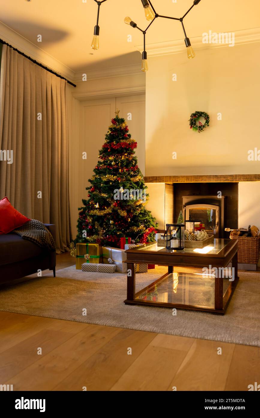 Dekorierter weihnachtsbaum am Kamin im gemütlichen Wohnzimmer, Kopierraum Stockfoto