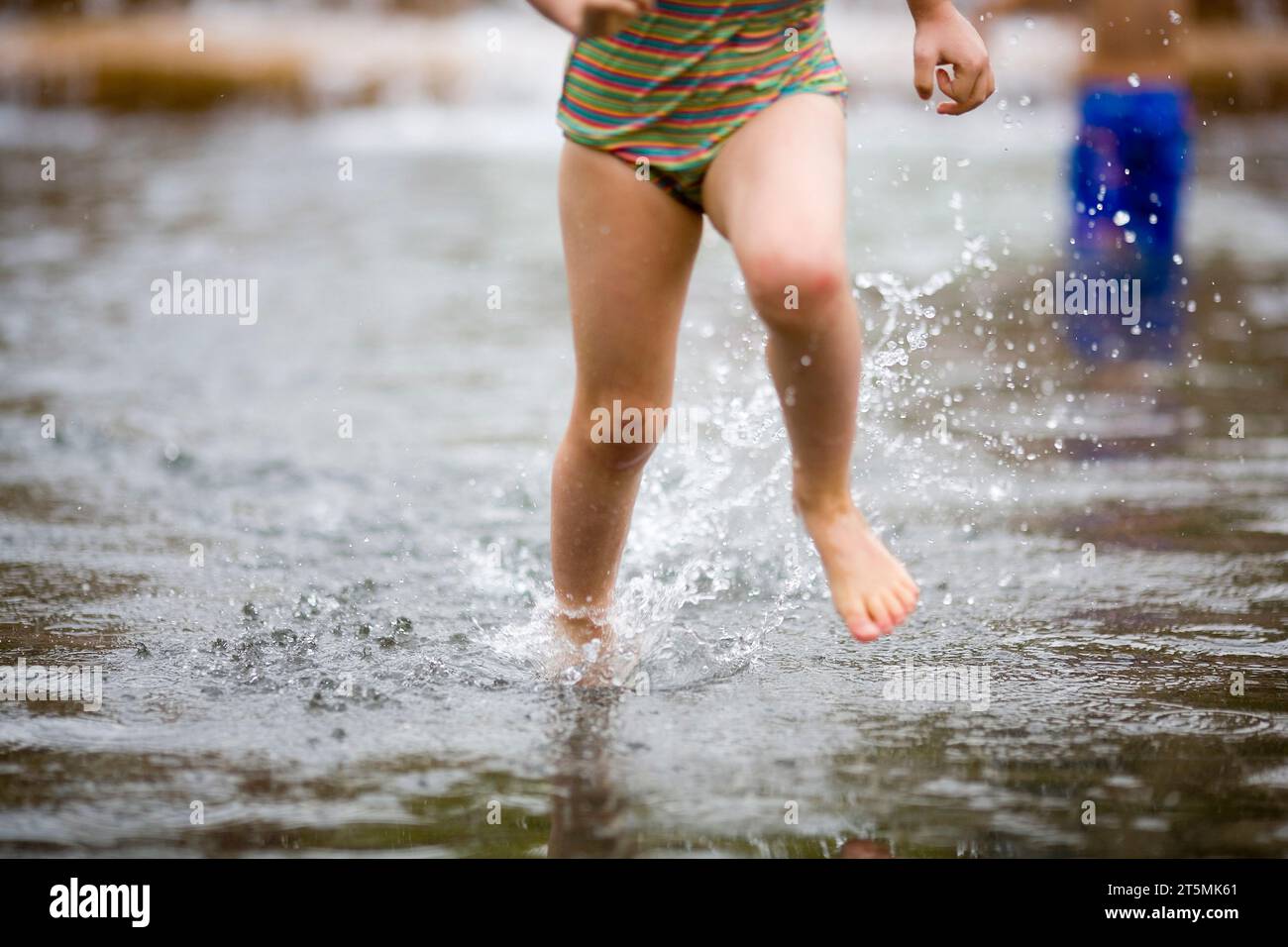 Das Mädchen rennt im Brunnen. Stockfoto