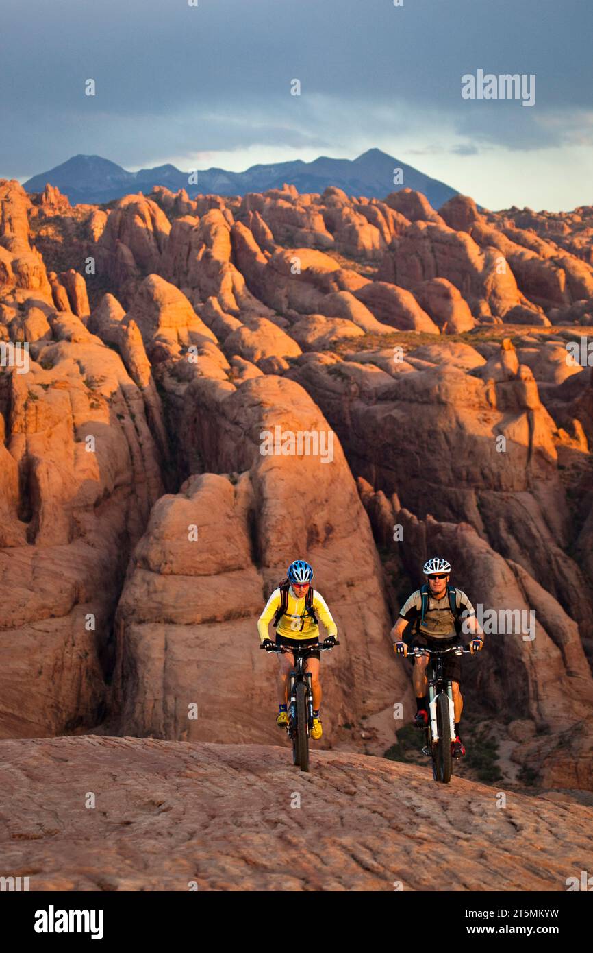 Ein paar Mountainbiker auf einer Felsformation in der Nähe von Moab, Utah. Stockfoto