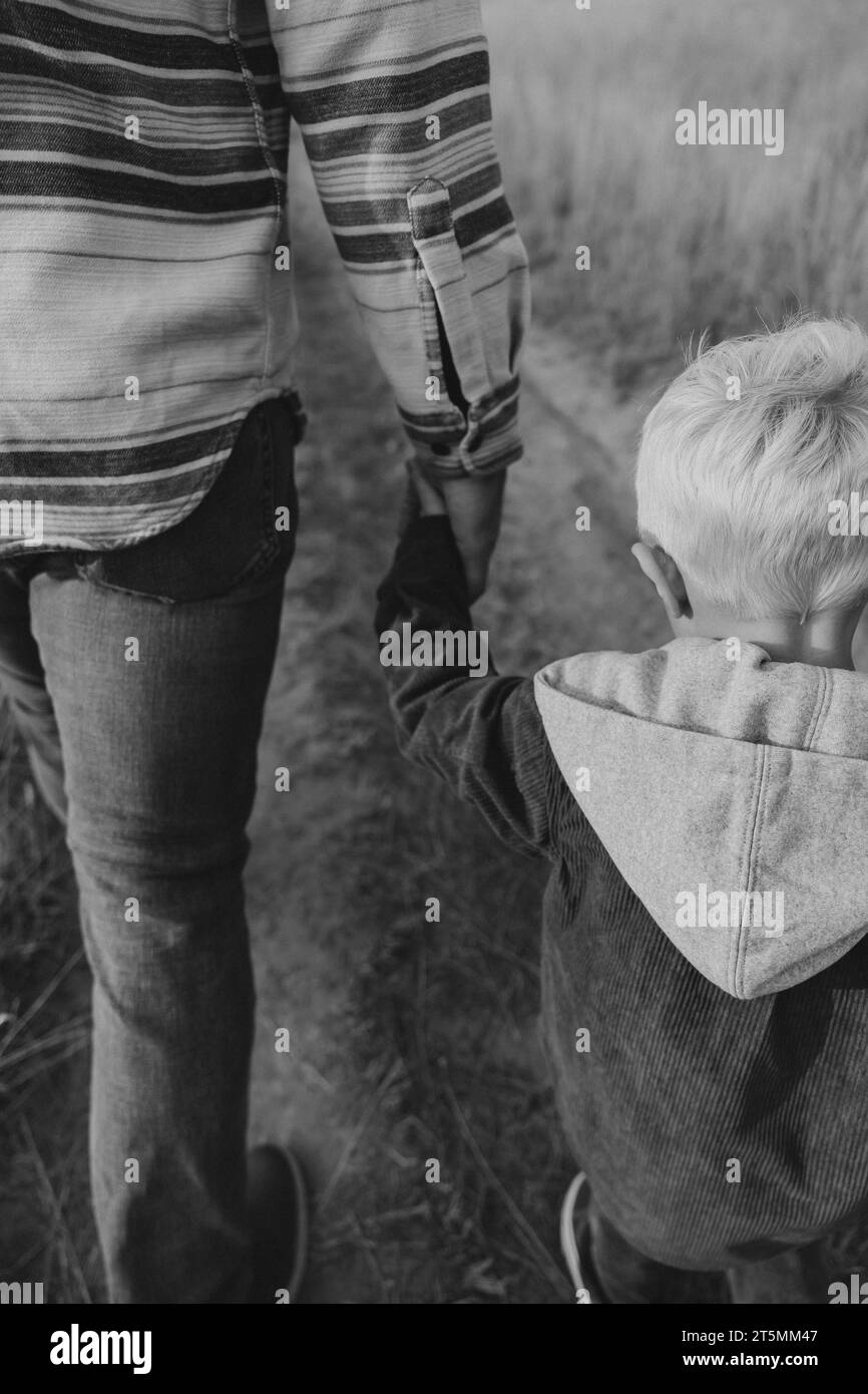 Vater und Sohn halten Hände auf einem Spaziergang Stockfoto