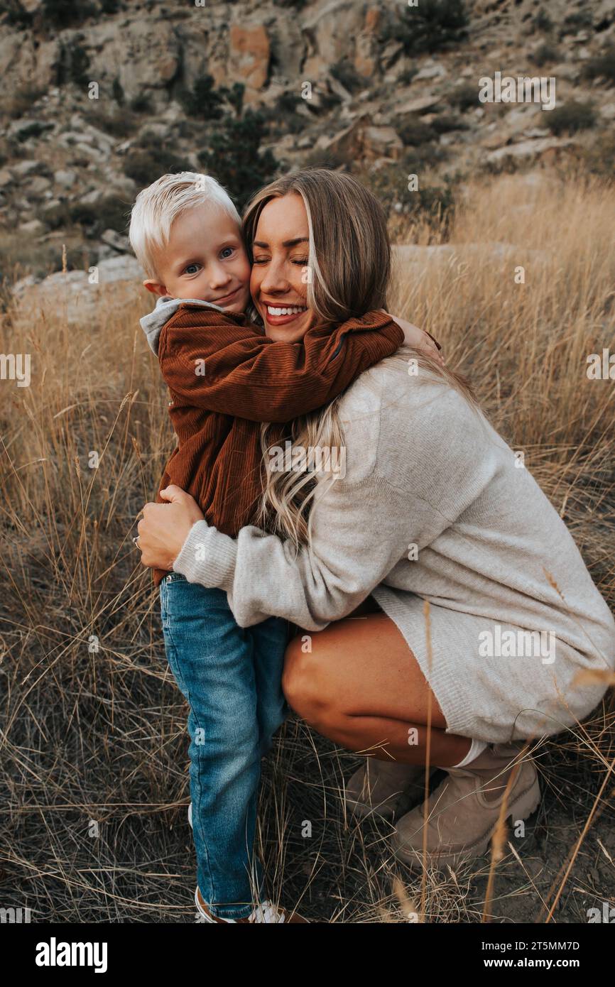 Mutter umarmt den vierjährigen Sohn an einem schönen Herbsttag Stockfoto