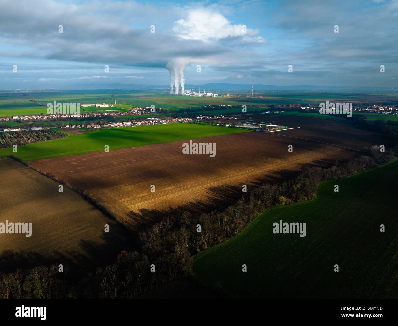 Luftaufnahme eines Kernkraftwerks mit hoch aufragenden Kühltürmen, die Dampf abgeben. Stockfoto