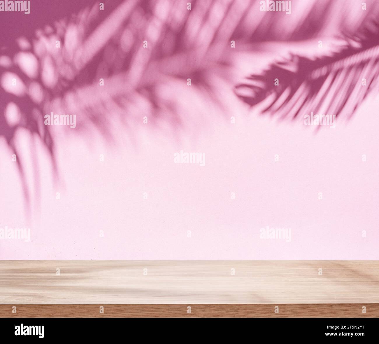 Verschwommener Schatten tropischer Palmenblätter an der pinken Wand und der Tischplatte im Vordergrund. Sommerkonzept. Stockfoto