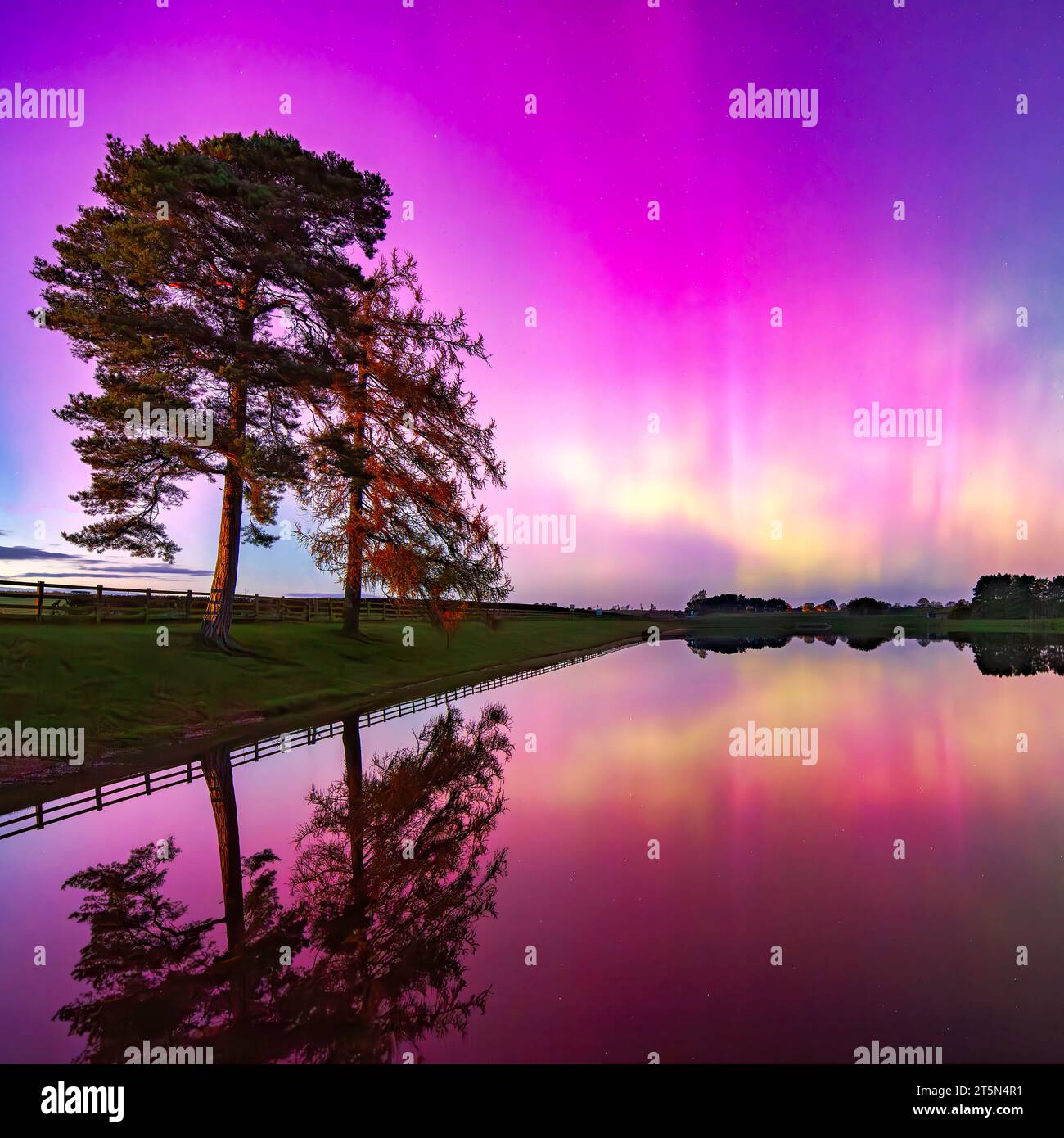 Die Nordlichter ( Aurora Borealis ) über dem Whittle Dene Reservoir in Northumberland mit Reflexionen im Wasser Stockfoto