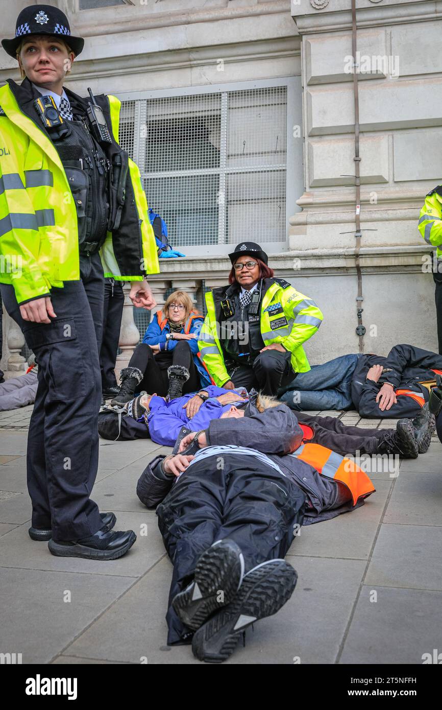 London, Großbritannien. November 2023. Demonstranten von Just Stop Oil blockieren Teile der Straße auf Whitehall in der Nähe des Cenotaph und der Downing Street in einem Sit in (von einigen als „sterben in“ bezeichnet) Protest. Diejenigen, die den Protest fortsetzen, werden dann von Polizisten weggebracht und in Polizeiwagen gebracht, wo mehrere verhaftet werden und auf mögliche Anklagen warten. Quelle: Imageplotter/Alamy Live News Stockfoto