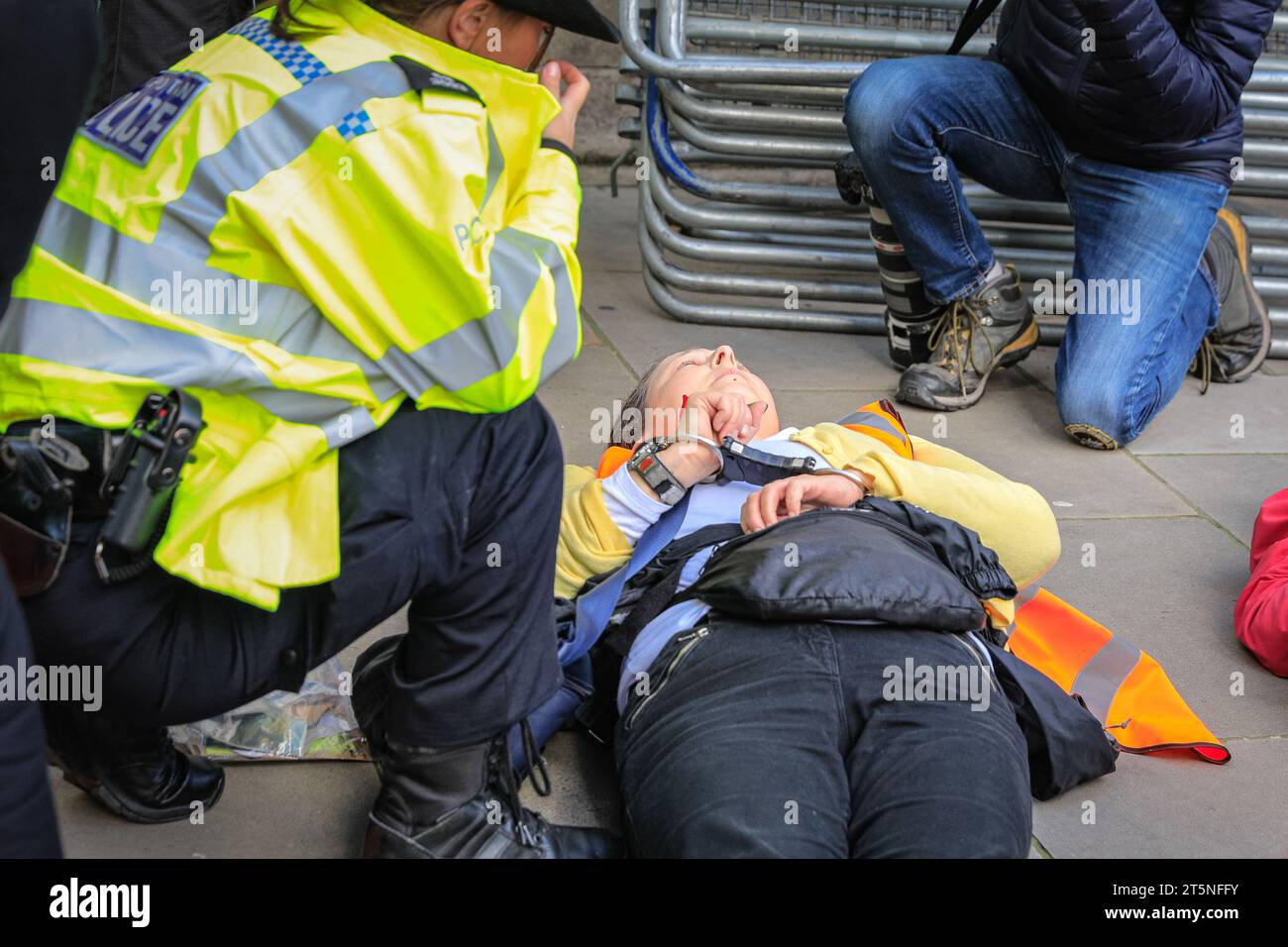 London, Großbritannien. November 2023. Demonstranten von Just Stop Oil blockieren Teile der Straße auf Whitehall in der Nähe des Cenotaph und der Downing Street in einem Sit in (von einigen als „sterben in“ bezeichnet) Protest. Diejenigen, die den Protest fortsetzen, werden dann von Polizisten weggebracht und in Polizeiwagen gebracht, wo mehrere verhaftet werden und auf mögliche Anklagen warten. Quelle: Imageplotter/Alamy Live News Stockfoto