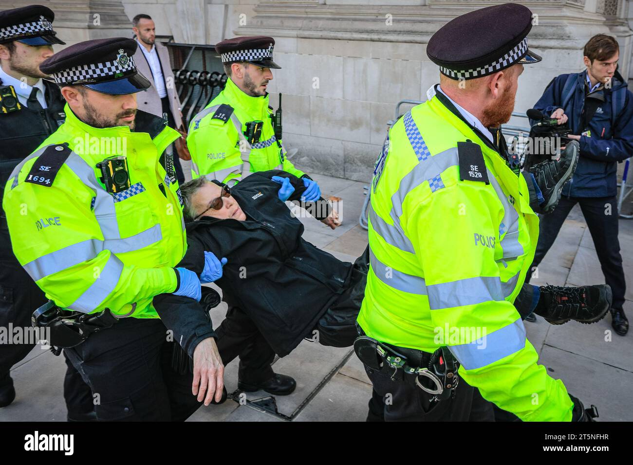 London, Großbritannien. November 2023. Demonstranten von Just Stop Oil blockieren Teile der Straße auf Whitehall in der Nähe des Cenotaph und der Downing Street in einem Sit in (von einigen als „sterben in“ bezeichnet) Protest. Diejenigen, die den Protest fortsetzen, werden dann von Polizisten weggebracht und in Polizeiwagen gebracht, wo mehrere verhaftet werden und auf mögliche Anklagen warten. Quelle: Imageplotter/Alamy Live News Stockfoto