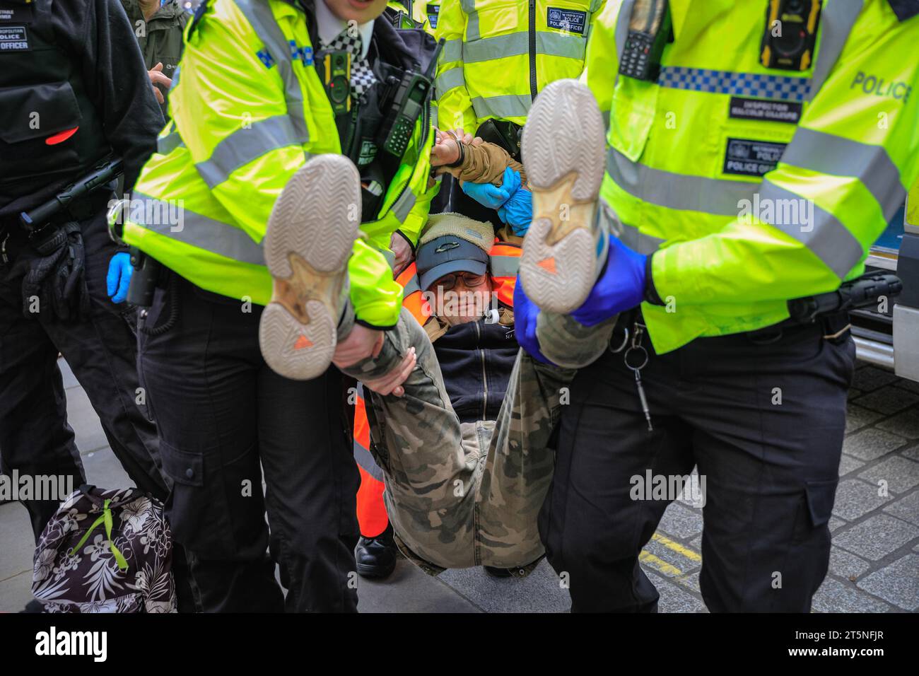 London, Großbritannien. November 2023. Demonstranten von Just Stop Oil blockieren Teile der Straße auf Whitehall in der Nähe des Cenotaph und der Downing Street in einem Sit in (von einigen als „sterben in“ bezeichnet) Protest. Diejenigen, die den Protest fortsetzen, werden dann von Polizisten weggebracht und in Polizeiwagen gebracht, wo mehrere verhaftet werden und auf mögliche Anklagen warten. Quelle: Imageplotter/Alamy Live News Stockfoto