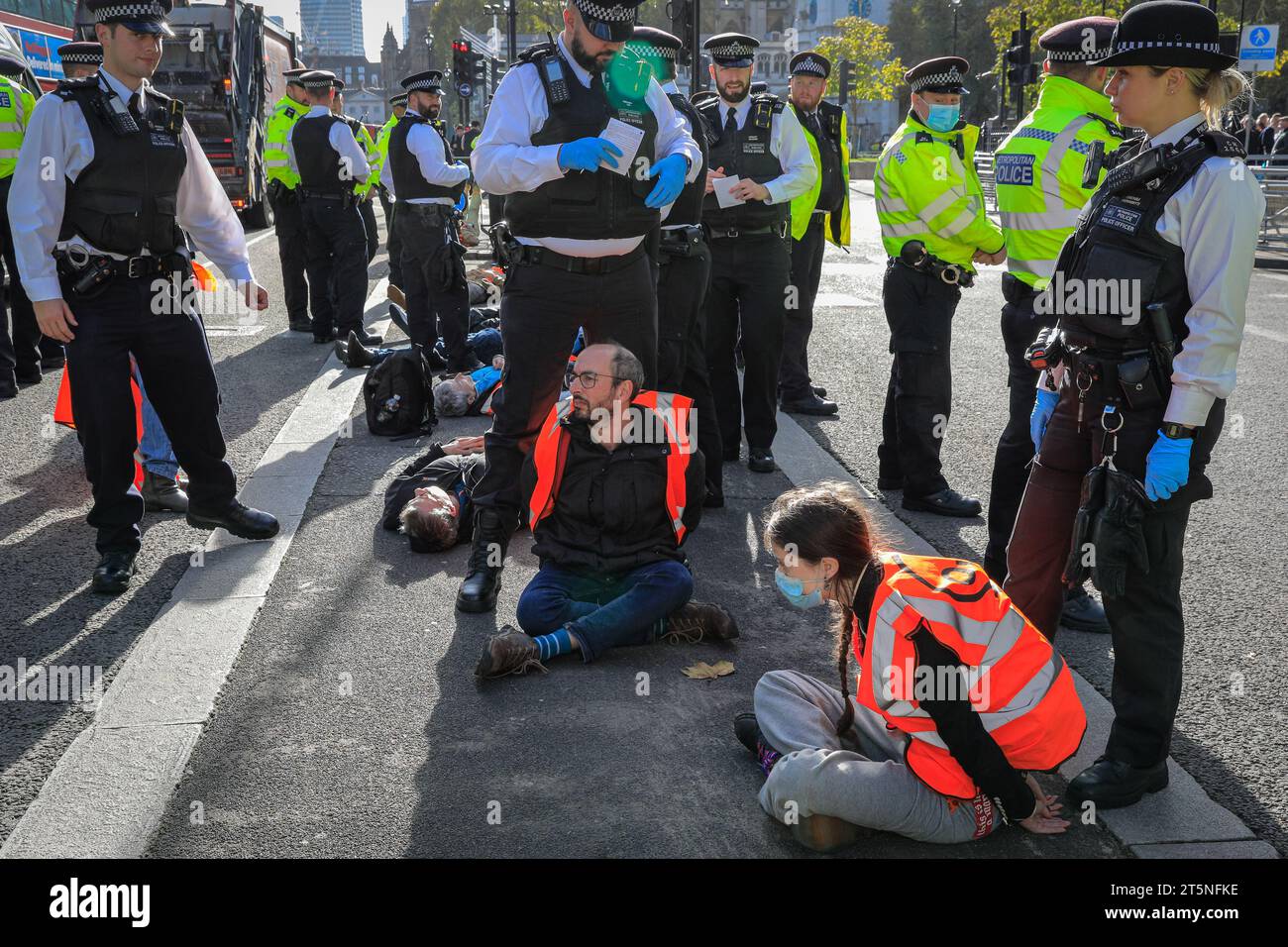 London, Großbritannien. November 2023. Demonstranten von Just Stop Oil blockieren Teile der Straße auf Whitehall in der Nähe des Cenotaph und der Downing Street in einem Sit in (von einigen als „sterben in“ bezeichnet) Protest. Diejenigen, die den Protest fortsetzen, werden dann von Polizisten weggebracht und in Polizeiwagen gebracht, wo mehrere verhaftet werden und auf mögliche Anklagen warten. Quelle: Imageplotter/Alamy Live News Stockfoto