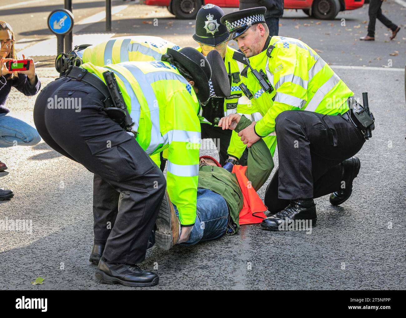 London, Großbritannien. November 2023. Demonstranten von Just Stop Oil blockieren Teile der Straße auf Whitehall in der Nähe des Cenotaph und der Downing Street in einem Sit in (von einigen als „sterben in“ bezeichnet) Protest. Diejenigen, die den Protest fortsetzen, werden dann von Polizisten weggebracht und in Polizeiwagen gebracht, wo mehrere verhaftet werden und auf mögliche Anklagen warten. Quelle: Imageplotter/Alamy Live News Stockfoto