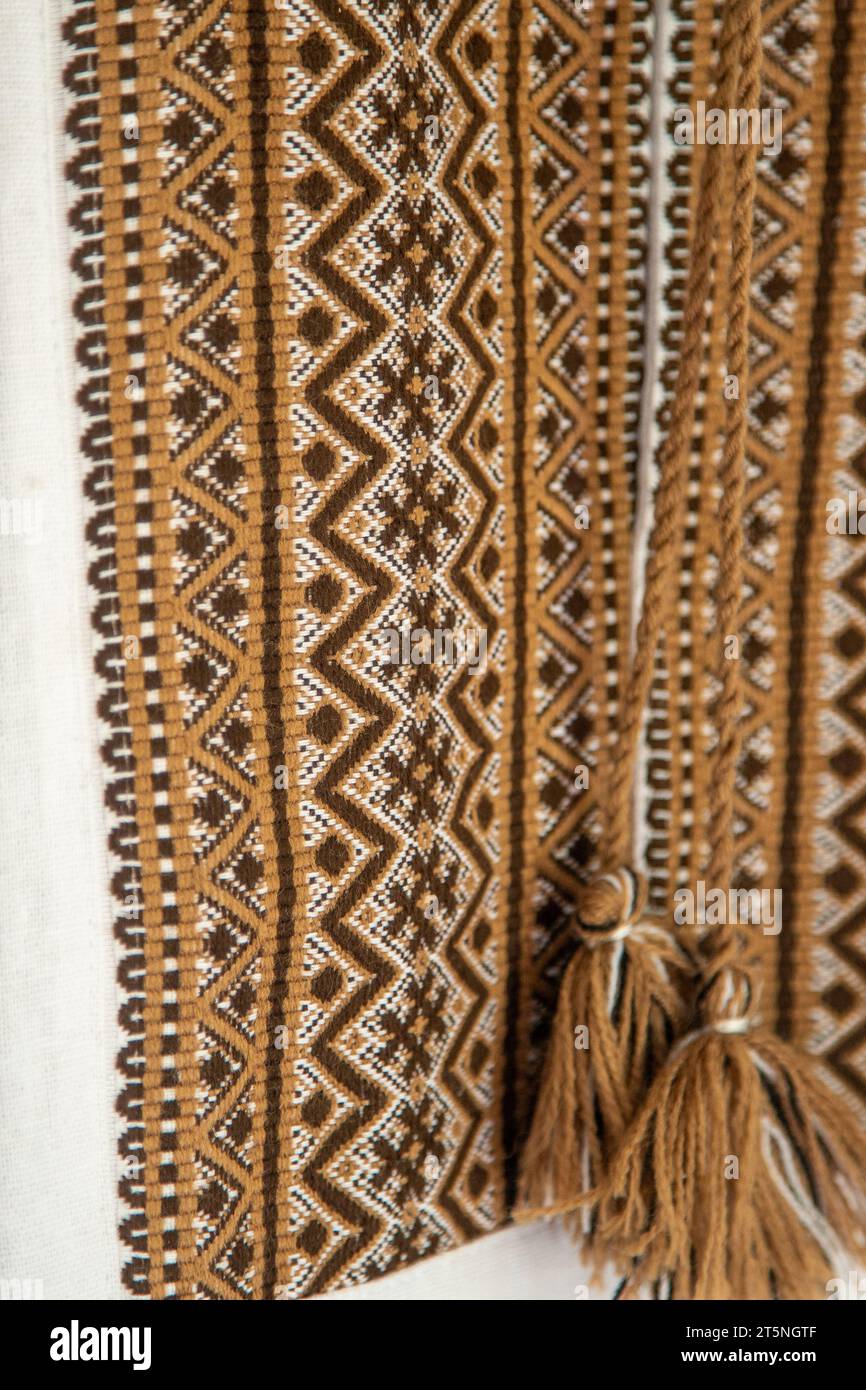 Ukrainisches Hemd mit Stickerei. Braunes Beige und weißer schwarzer Hintergrund. Vyshyvanka Symbol der Ukraine. Kreuzstitmuster. Ukrainischer Nationalstich. Traditionelle Kleidung. Stockfoto