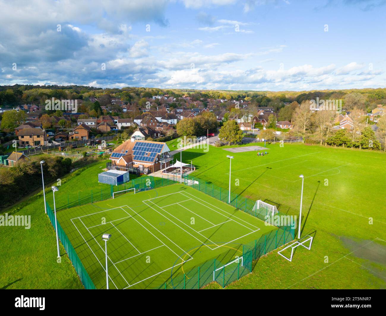 Aus der Vogelperspektive auf einen Sportkomplex mit Tennisplätzen und Fußballfeldern in einem Vorstadtgebiet an einem sonnigen Tag, Hamstreet Village, Ashford, Kent Stockfoto