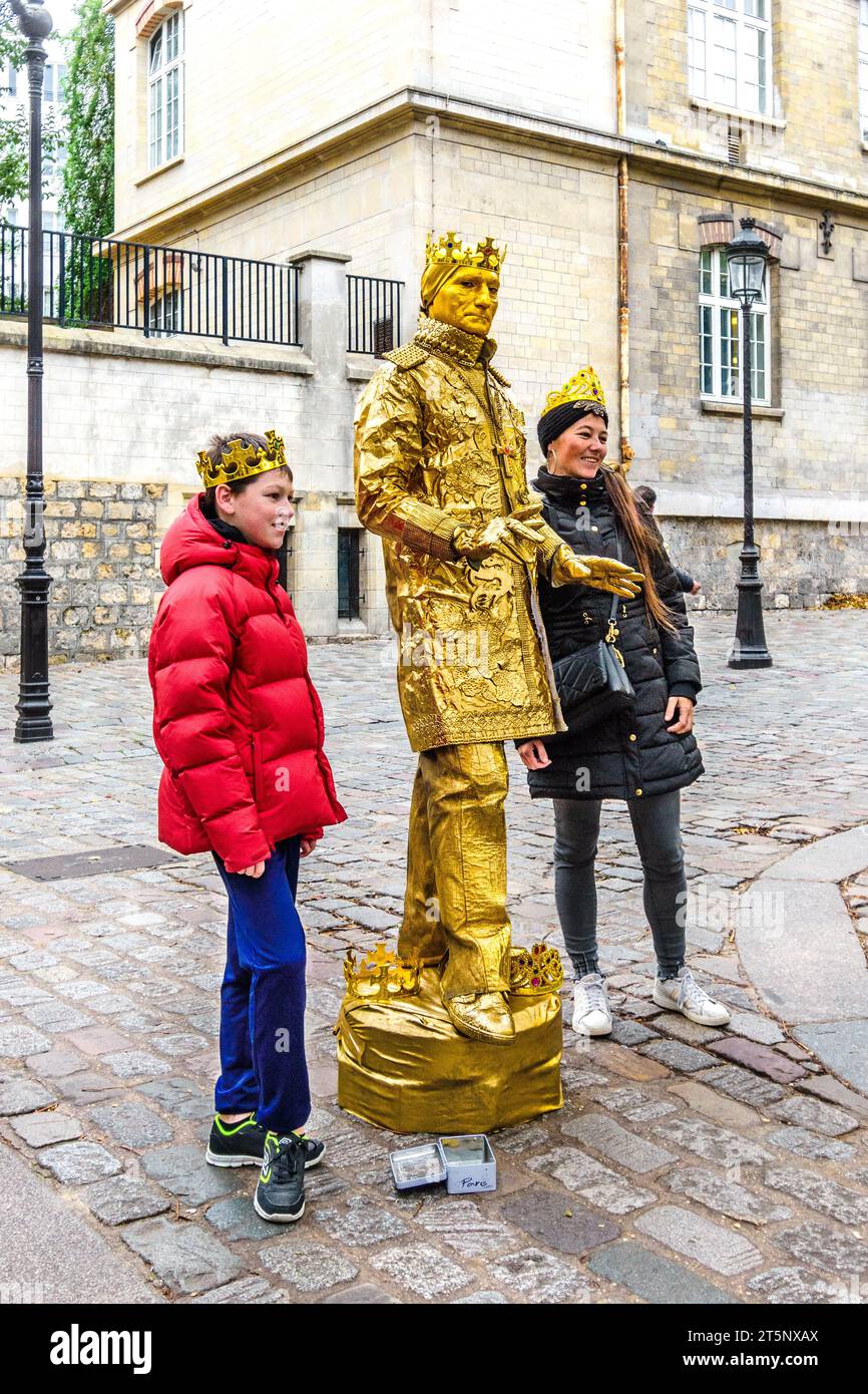 Mann in goldener Kleidung posiert mit Touristen in Montmartre, Paris 18, Frankreich. Stockfoto