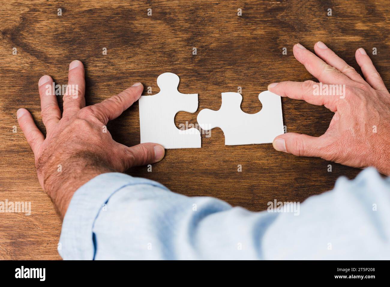 Draufsicht Hände machen Puzzle Holztisch Stockfoto
