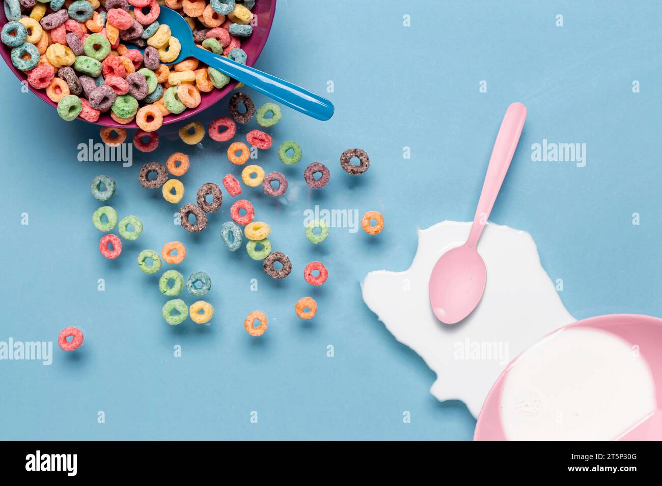 Schüssel Müsli spritzt Milch mit rosafarbenem Löffel Stockfoto