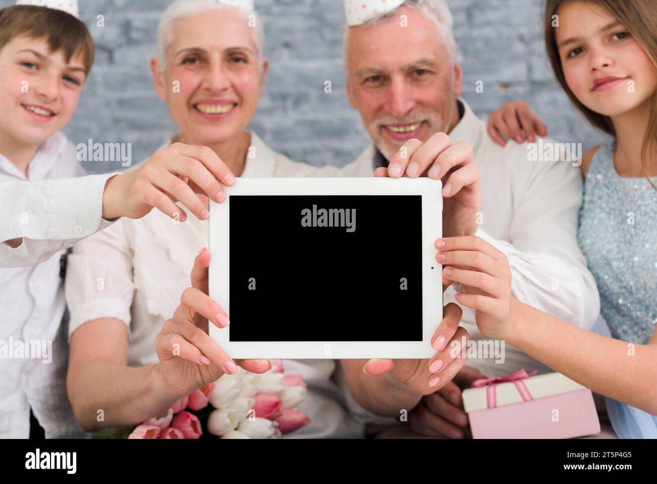 Glückliche Familie zeigt ein digitales Tablet mit leerem Bildschirm Stockfoto