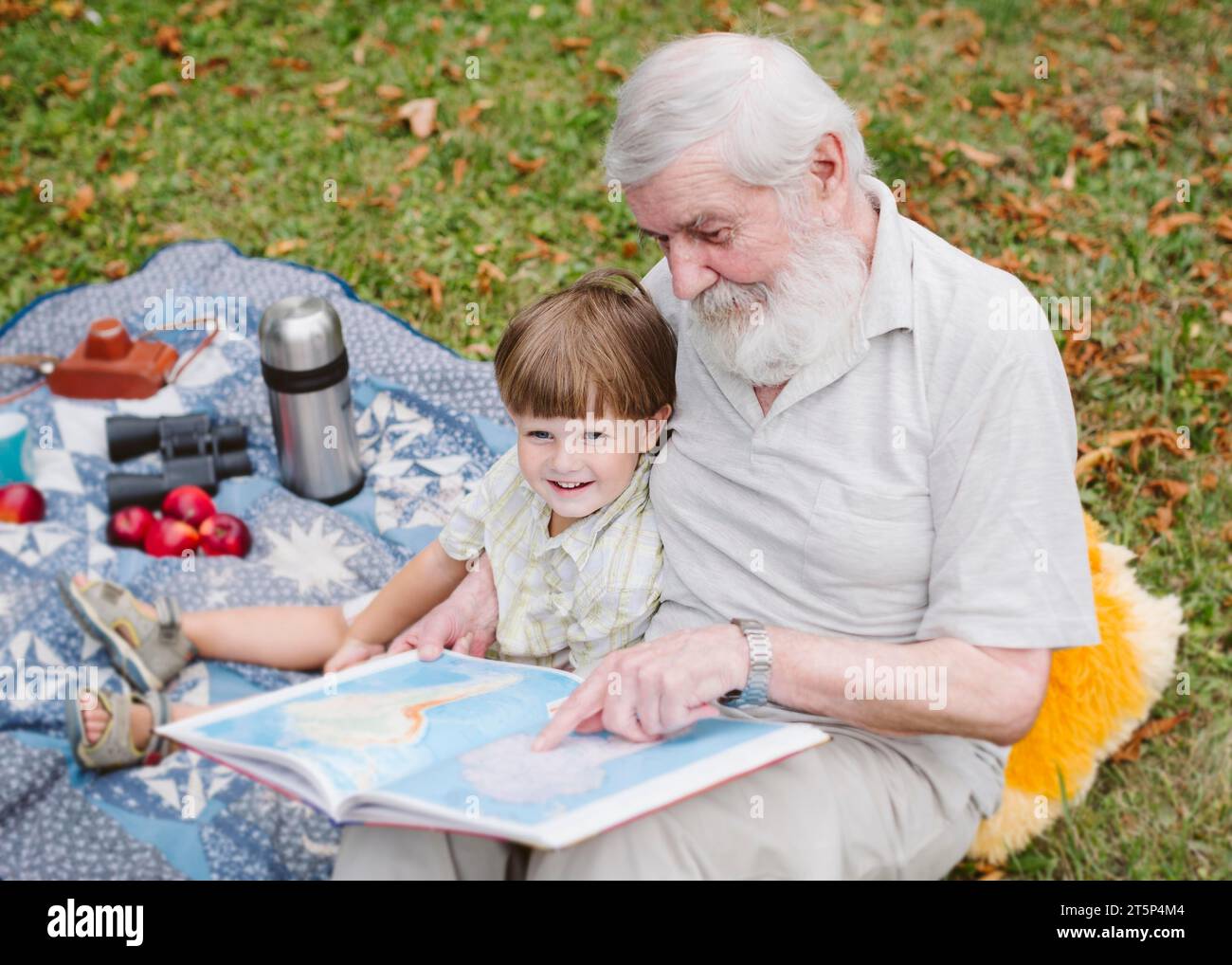 Großvater liest Enkel Stockfoto