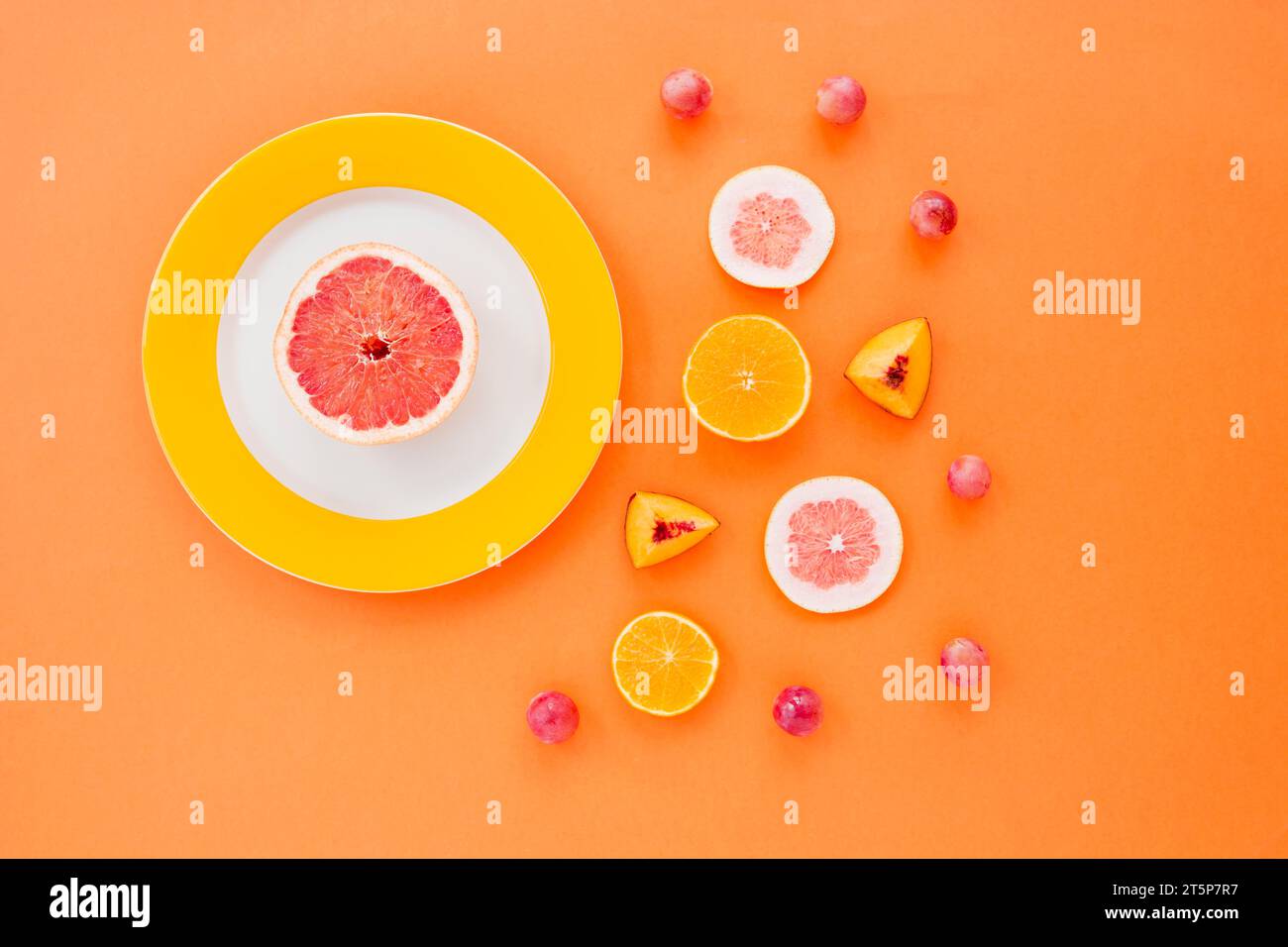 Zitrusfrucht Pfirsichscheiben Trauben orange Hintergrund Stockfoto
