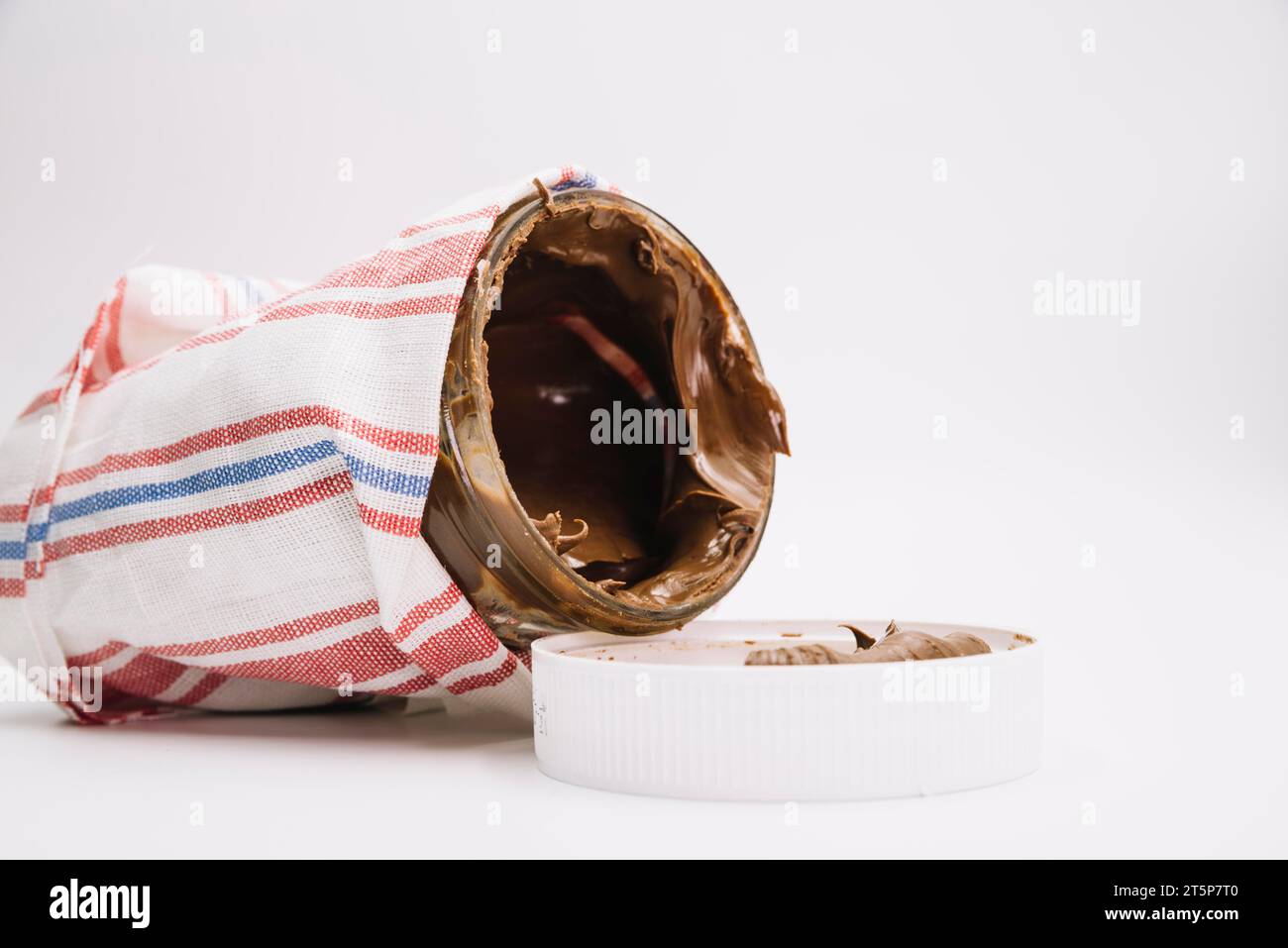 Schokoladenaufstrichglas umwickelte Serviette mit offenem Deckel weißem Hintergrund Stockfoto