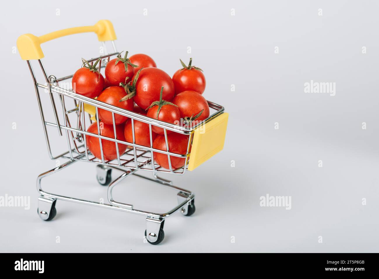 Trolley mit frischen Bio-Tomaten und weißem Hintergrund Stockfoto