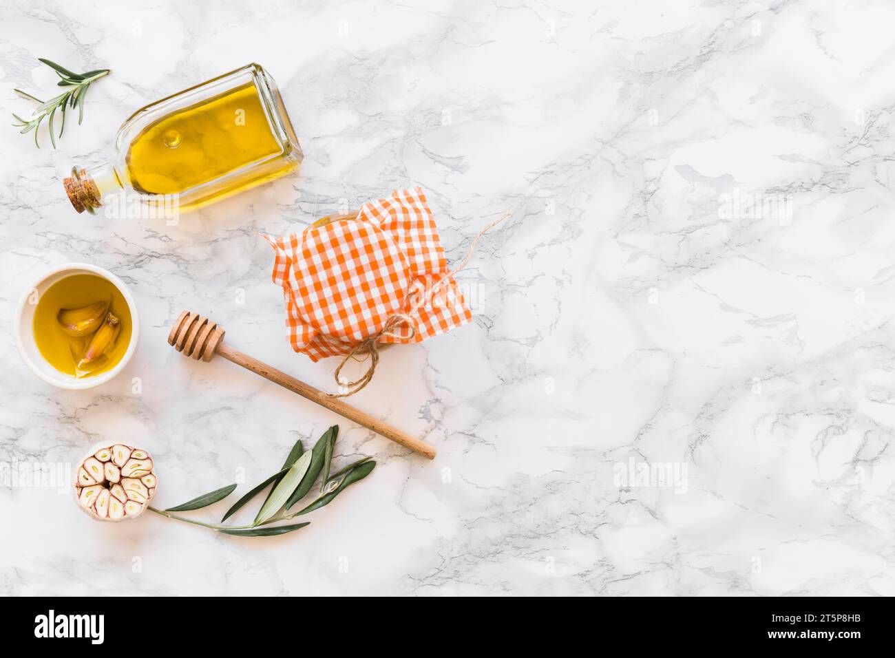 Knoblauchzehenöl mit weißem Marmor im Glas Stockfoto