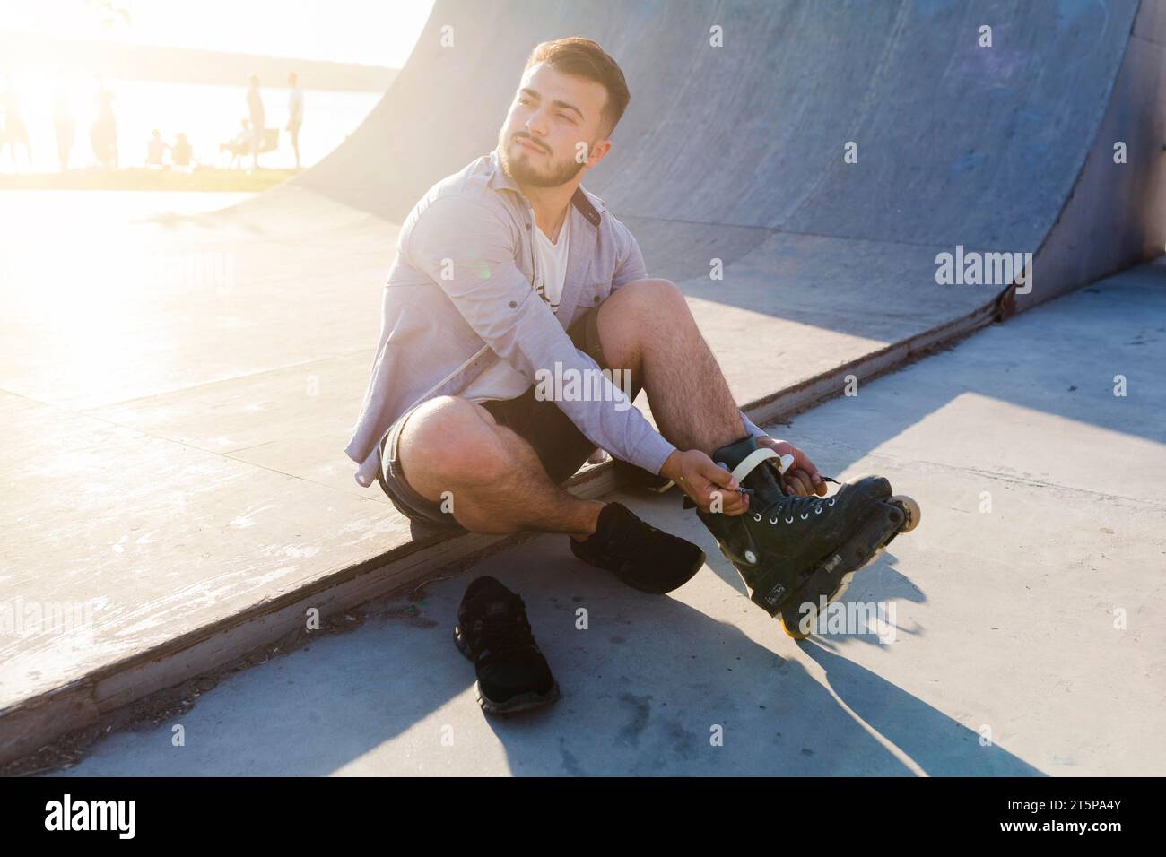 Junger Mann, der Rollerskates im Skatepark macht Stockfoto