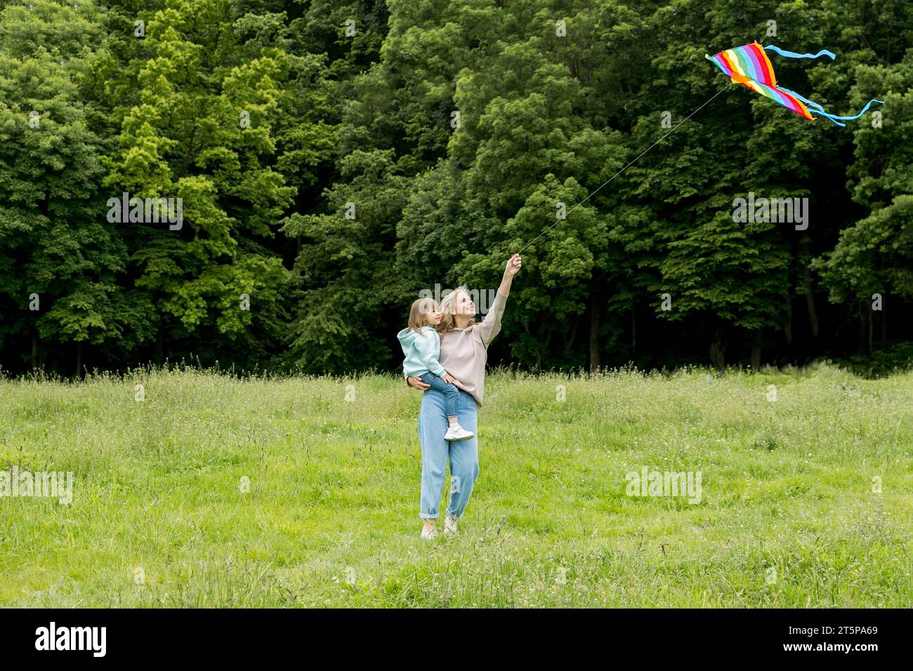 Junge im Freien, Mutter spielt mit Drachen Stockfoto