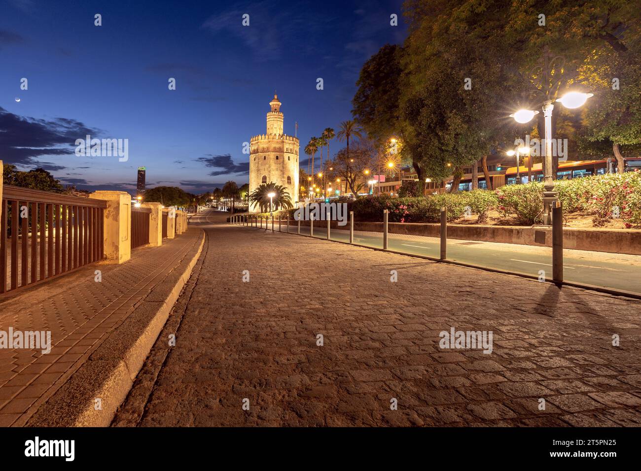 Malerischer Blick auf die Stadtpromenade und den goldenen Turm von Torre del Oro bei Sonnenuntergang in Sevilla. Spanien. Andalusien. Stockfoto
